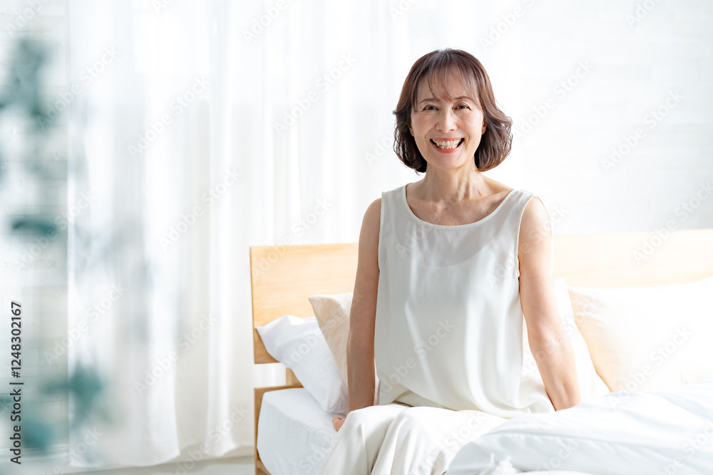 ベッドに座る日本人シニア女性 ベッドに座る日本人シニア女性
