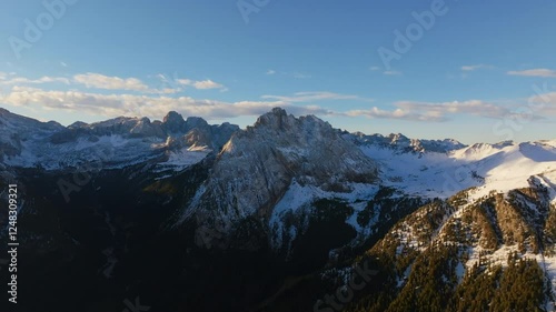 Wide aerial footage of Piccolo Vernel, mountain in the Marmolada Range of the Dolomites in Italy bathed in the morning light. photo