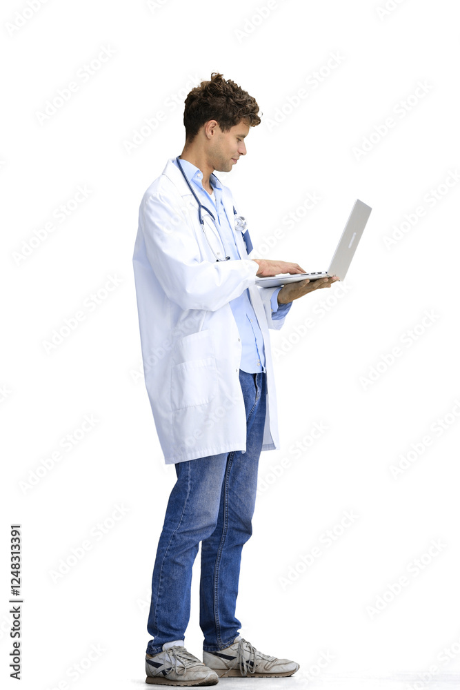 A male doctor, on a white background, in full height, uses a laptop A male doctor, on a white background, in full height, uses a laptop