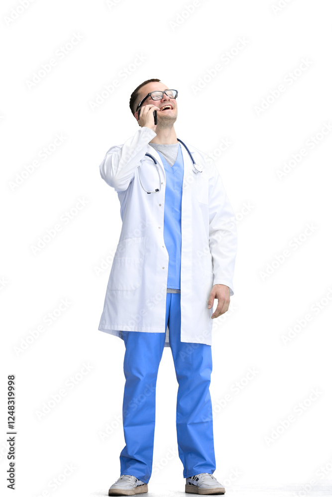 A male doctor, on a white background, in full height, uses a phone