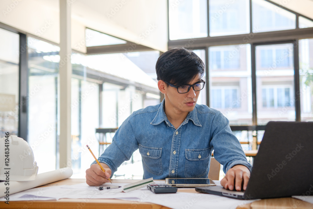 Architect working on blueprints at a modern workspace