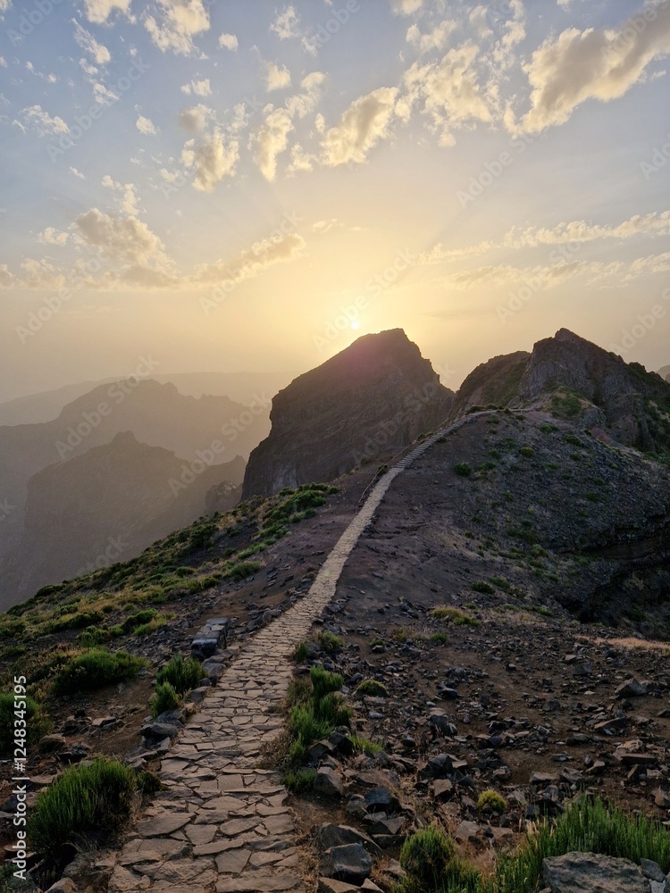 Obraz premium A stone path leading toward a majestic mountain peak at sunset, Pico do Arieiro, Madeira, Portugal