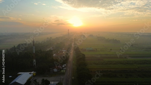 Aerial drone view of the highway that crosses a coutryside with sunrise and morning mist in the background photo