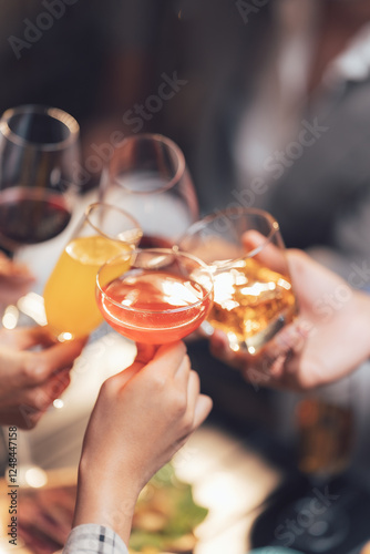 Cheers to Friendship: Four hands raise glasses filled with different beverages – red wine, orange juice, a pink cocktail and whiskey – in a toast of camaraderie and celebration.