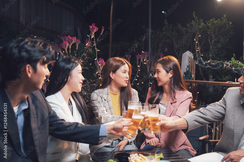 Φωτογραφία Nighttime Cheers: Friends in Business Attire Celebrate: A group of stylish young professionals raises their drinks in a celebratory toast during a lively night out at an outdoor restaurant or bar