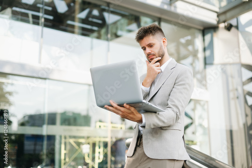 Wallpaper Mural Handsome unshaven businessman walking with laptop, tablet and smartphone on city Torontodigital.ca