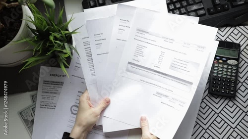 Hands with utility bills top view, water and heat service charges, home budget and financial report