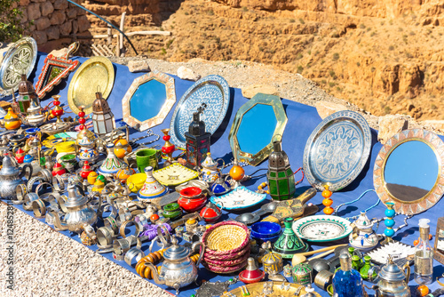 Multicolored Moroccan craft souvenirs at the market. Teapots and plates , decorations, tagines,, trinkets photo