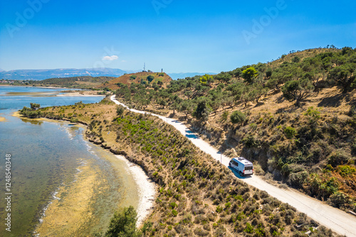 Camper van, RV or motor home is driving on gravel road from Zvernec beach or Dalan beach near Vlore, Albania