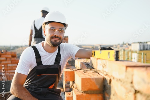 Construction worker in uniform and safety equipment have job on building. Industrial theme photo