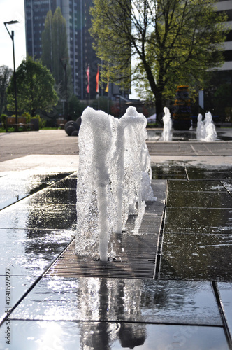 Water splashing from a fountain in a city square Katowi