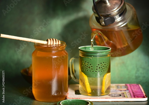 cup of tea, jar of honey and wooden spoon