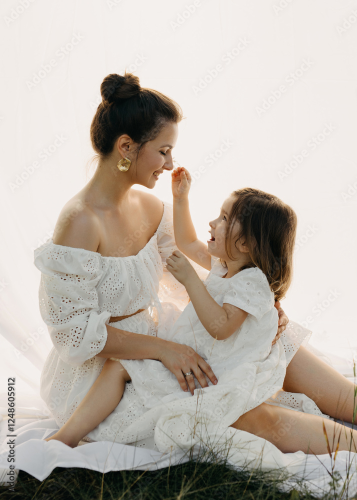 A mother and daughter share a joyful moment, dressed in white lace dresses, sitting on white background A mother and daughter share a joyful moment, dressed in white lace dresses, sitting on white background