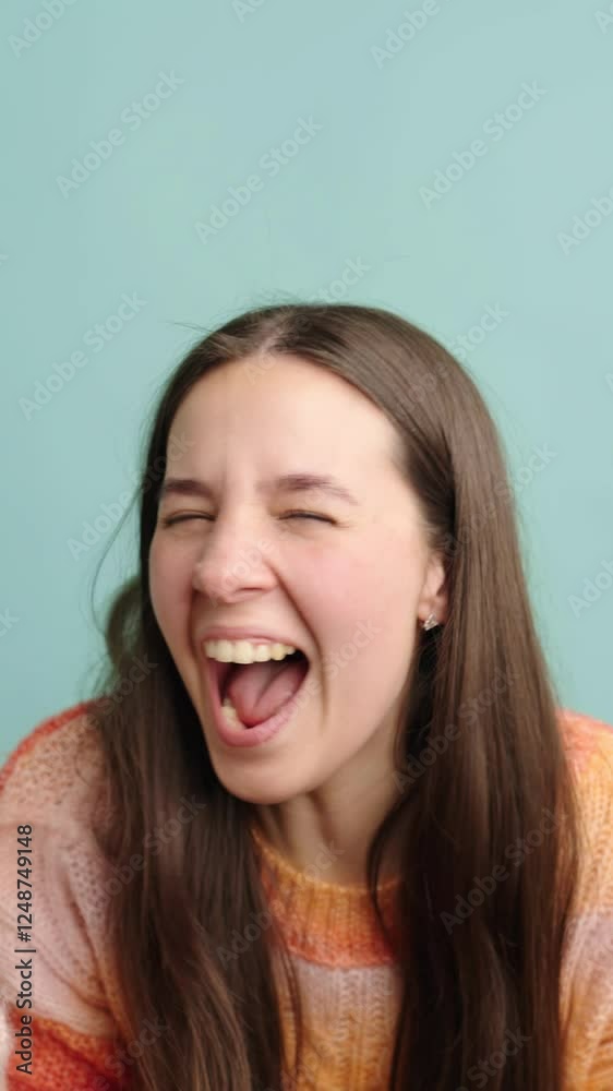 Expressive young woman laughing with joyful energy Expressive young woman laughing with joyful energy
