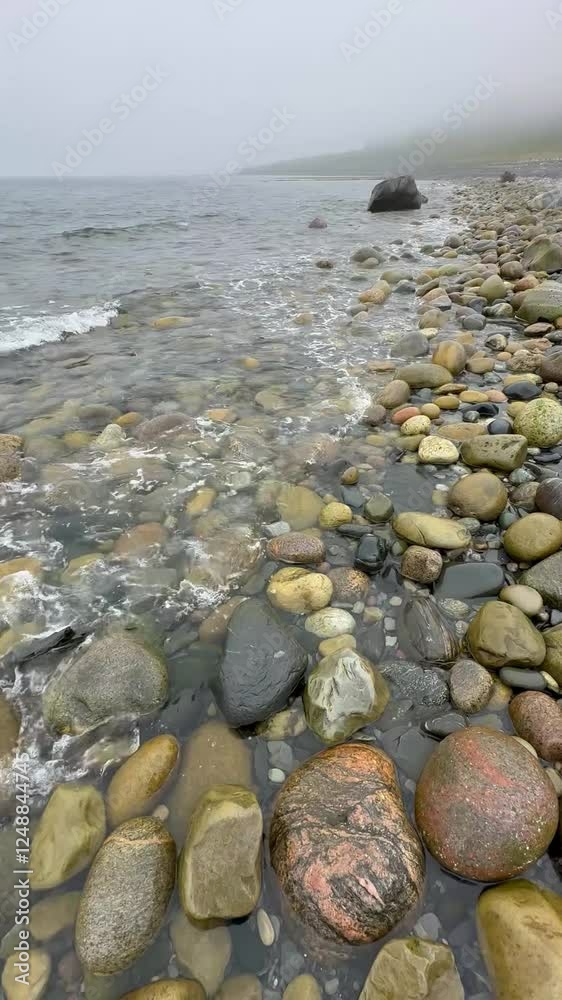 foggy seashore with round large stones and boulders