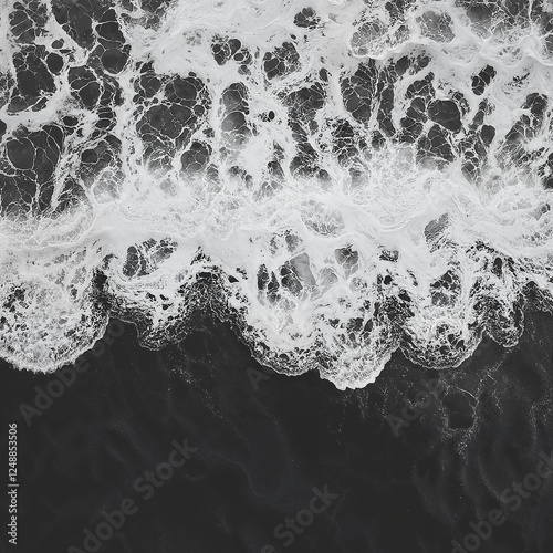 Black and white photograph of ocean waves. Aerial view, dark shore, crashing waves, deep black sea. Top view, abstract background.