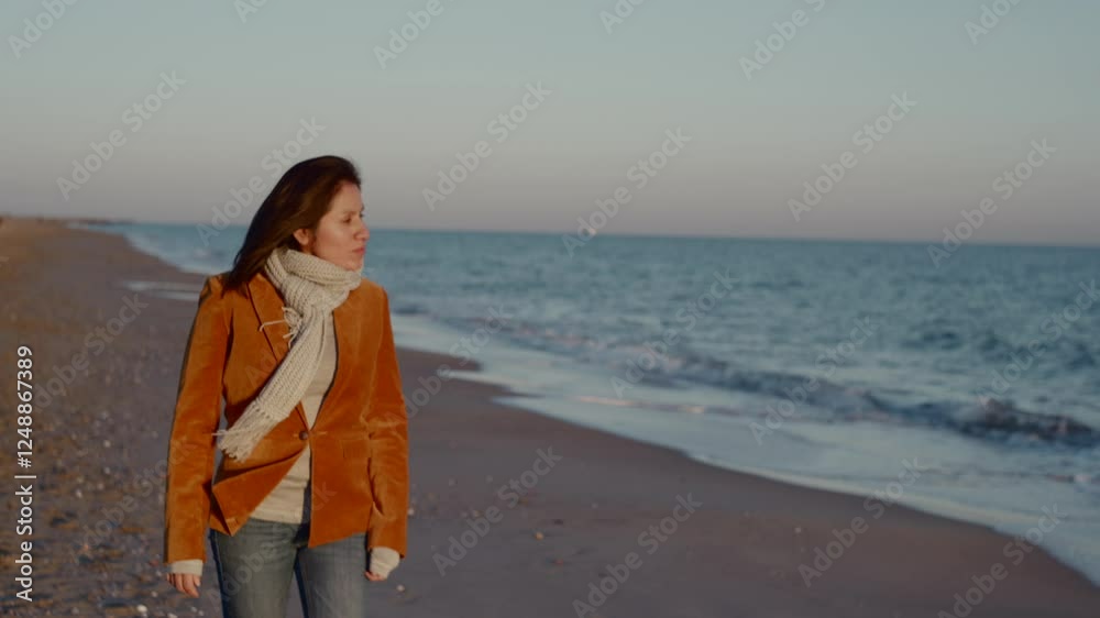 Woman in formal clothes and scarf walks along the Mediterranean Sea in Barcelona, on a winter afternoon. Woman in formal clothes and scarf walks along the Mediterranean Sea in Barcelona, on a winter afternoon.