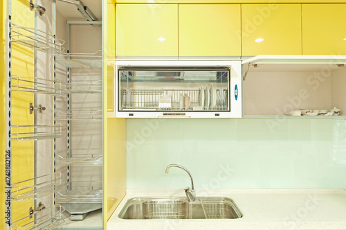 A newly installed modern kitchen with cabinets, two sinks, gas stove, fitted cupboards with red cupboard doors.