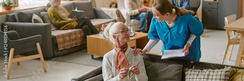 Website banner with young nurse patting senior woman who sitting on sofa and crocheting