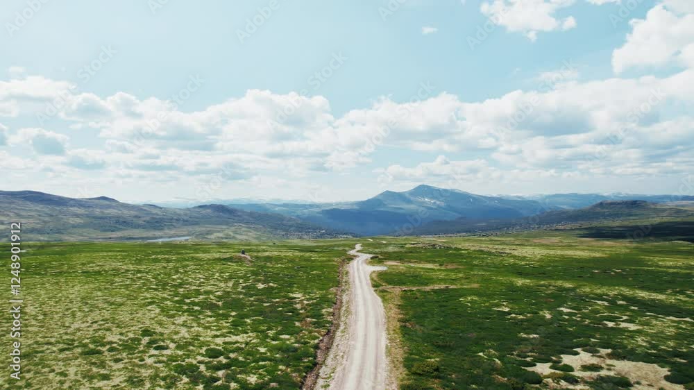 Drone follows 4x4 camper van drive on a gravel mountain road on sunny ...
