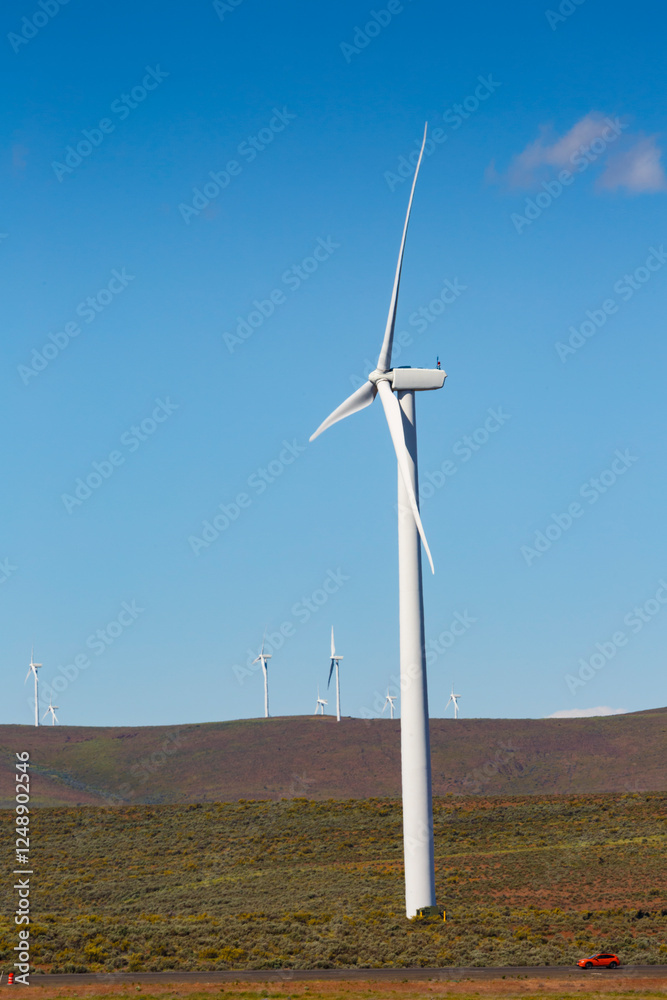 Wind turbines on the rolling hills of Kittikas county in Washington state, tall white towers with blades for energy generation. Wind turbines on the rolling hills of Kittikas county in Washington state, tall white towers with blades for energy generation.