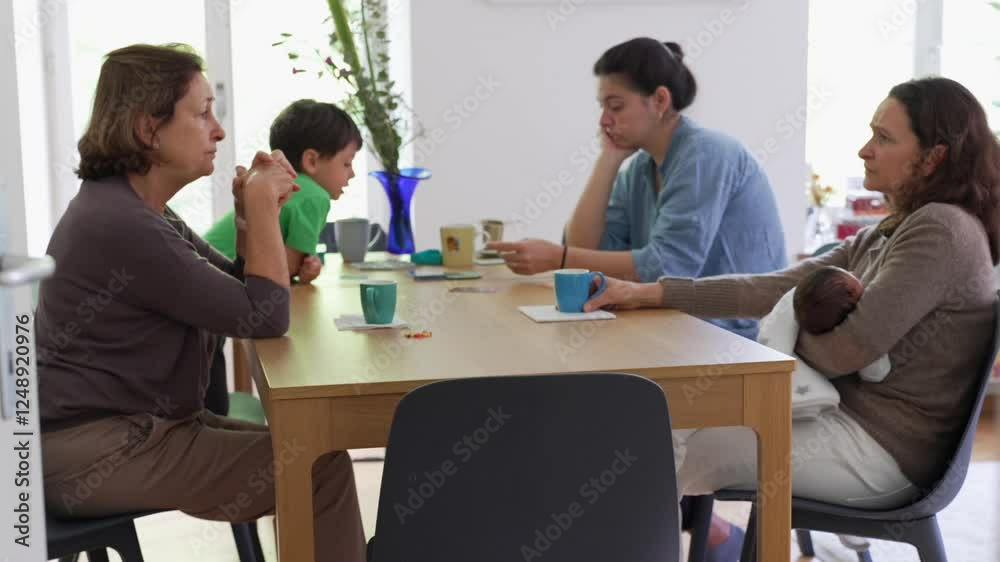 People conversing casually at home living-room over tea or coffee, candid authentic mother and adult daughters chatting People conversing casually at home living-room over tea or coffee, candid authentic mother and adult daughters chatting
