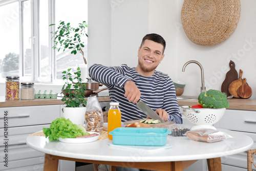 Young man cutting vegetable...