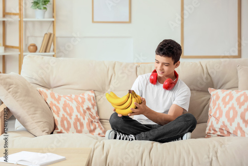 Teenage boy with bananas si...