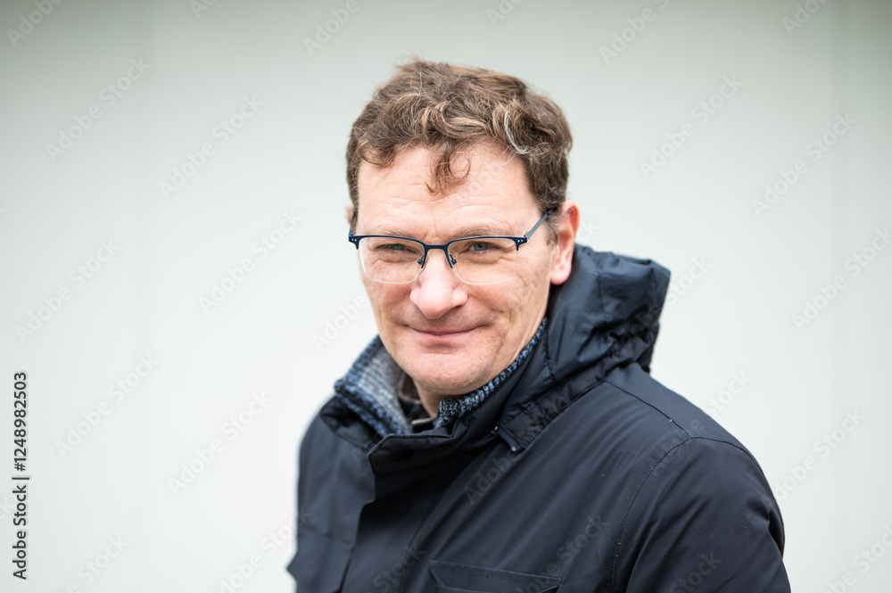 Portrait of a 45 yo white male wearing a dark winter jacket against a white background, Koekelberg, Brussels, Belgium Portrait of a 45 yo white male wearing a dark winter jacket against a white background, Koekelberg, Brussels, Belgium