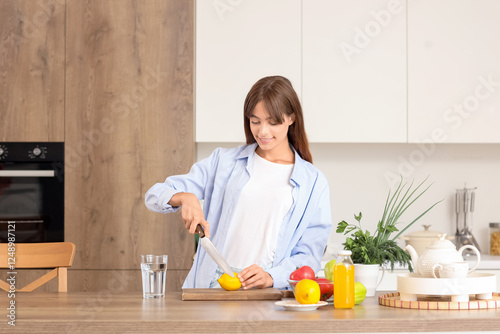 Young woman cutting lemon a...