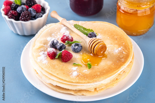 Traditional Maslenitsa food, Eastern European Slavic thin pancakes crepes, with various sweet spreads, toppings and fillings - honey, berries, jams  photo