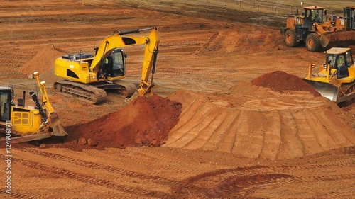 Heavy machinery at work in mining quarries moving earth and shaping terrain