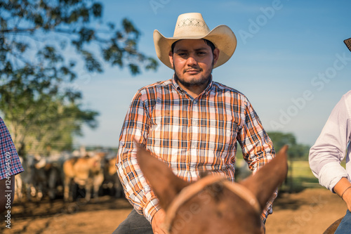 Portrait of a young cowboy. The cowboy looks proudly at the camera. photo