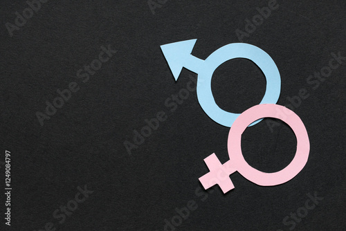 Female and male paper gender symbols on black background photo