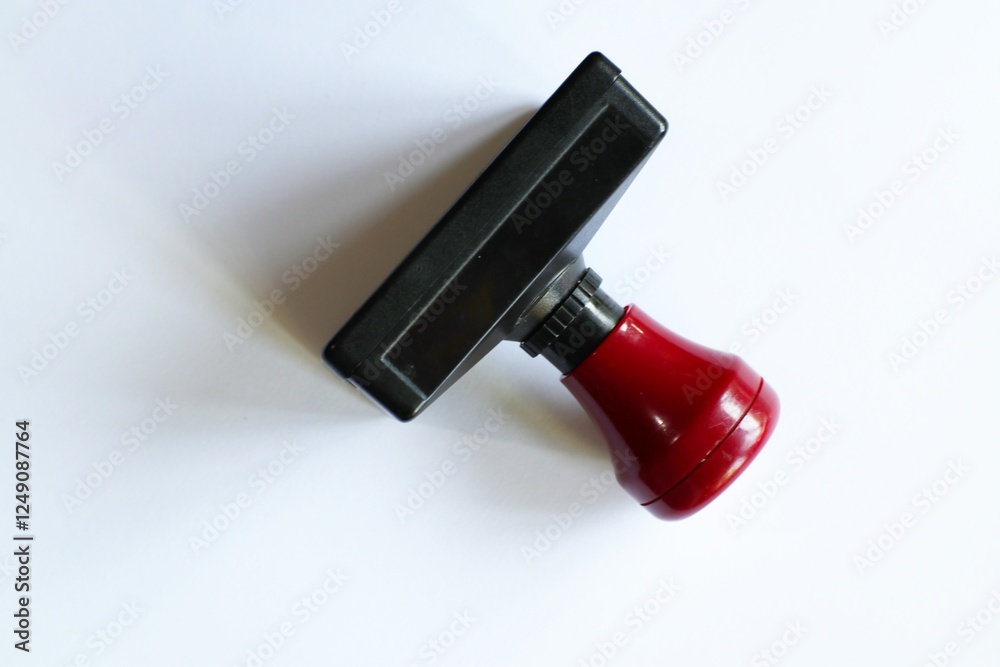 Fototapeta premium Close-up shot of black and red office stamp on a pristine white surface