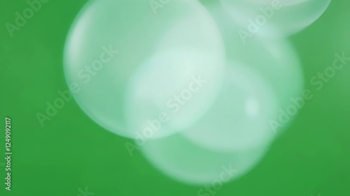 Luminous mist orbs glowing subtly casting a delicate sheen on the green surface below. Green screen chromakey