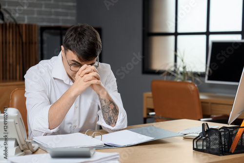 Worried young man at workpl...