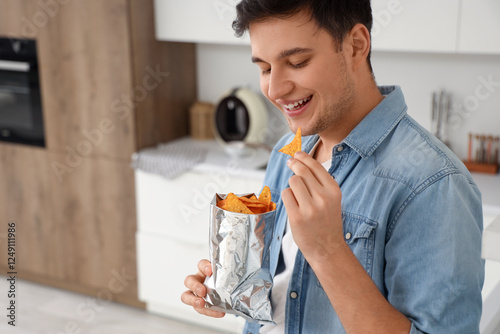 Young man eating tasty nach...