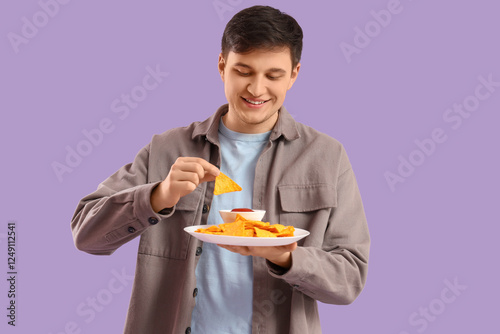Young man eating tasty nach...