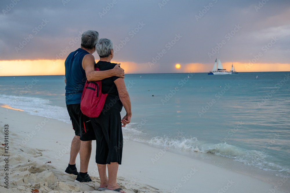 two pensioners seniors traveling and enjoying in a caribbean beach their holydais. sunset in the back ground with active senior couple two pensioners seniors traveling and enjoying in a caribbean beach their holydais. sunset in the back ground with active senior couple