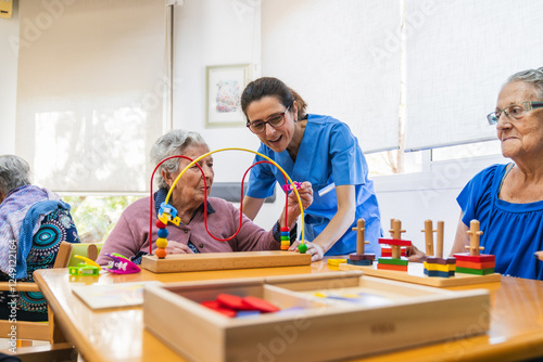 Fotografía Nurse assisting elderly woman with cognitive games in nursing home