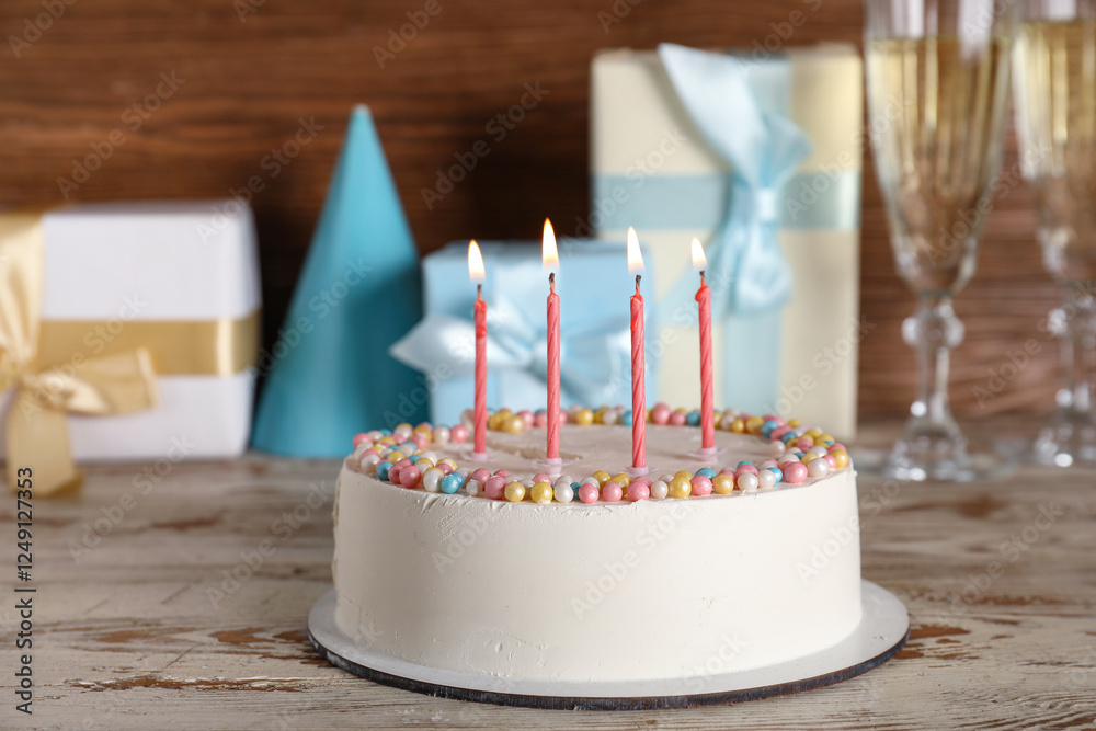 Φωτογραφία Tasty birthday cake with burning candles, gifts and glasses of champagne on ligh