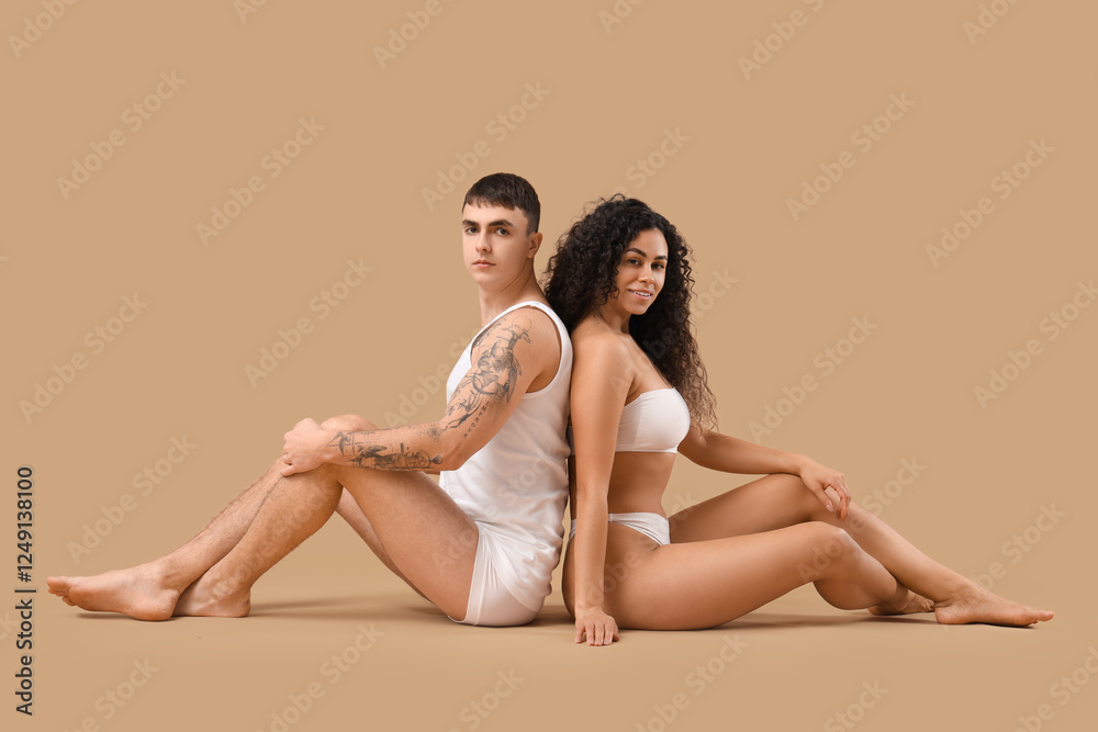 Young couple in stylish underwear on beige background Young couple in stylish underwear on beige background
