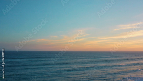 Ocean Sunset Horizon:  A serene seascape captures the beauty of a pastel sunset as it paints the sky with hues of pink and orange, while the deep blue ocean stretches into the distance.