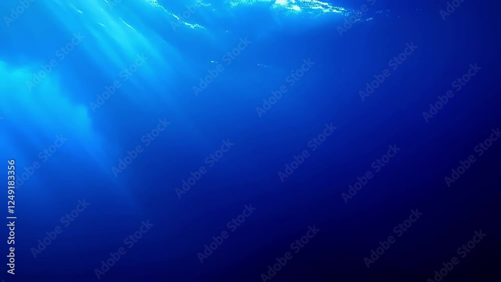 The water is blue and clear. There is a sunbeam shining through the water. The water is calm and still