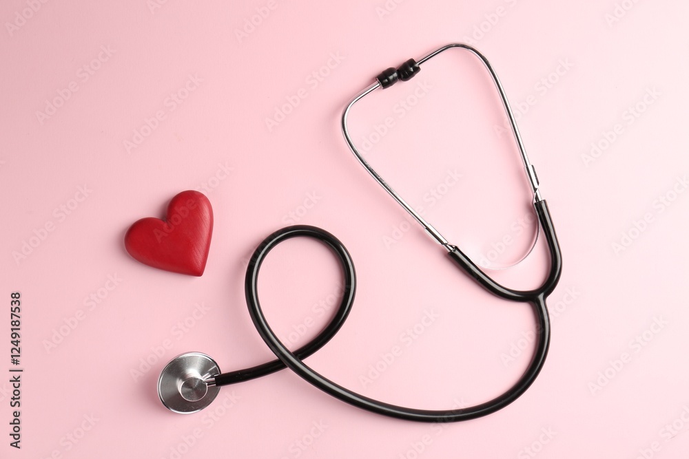 Cardiology. Stethoscope and red decorative heart on pale pink background, flat lay Cardiology. Stethoscope and red decorative heart on pale pink background, flat lay