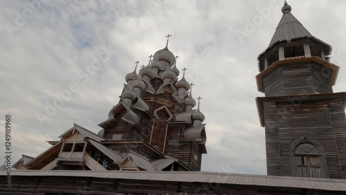 Kizhi Pogost. A historical site dating from the 17th century on Kizhi island. Russian wooden churches stand on a small island. Sunny weather. People walking are visible.