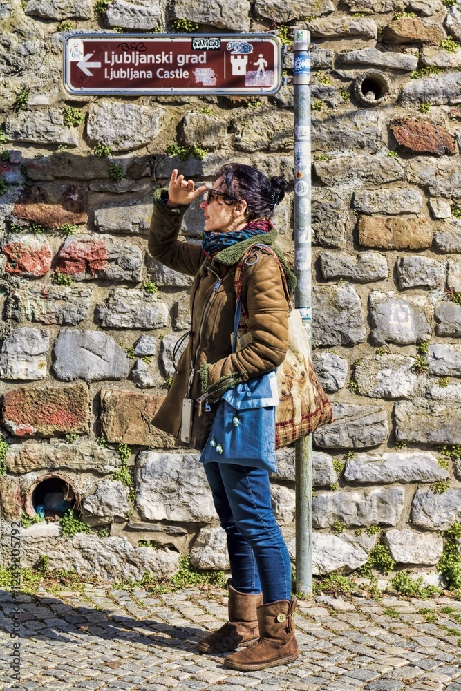 ljubljana, slowenien - eine frau hält an einem wegweiser ausschau