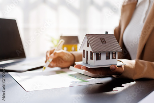 Female woman hand holding home model, investment small miniature white toy house. Mortgage property insurance dream moving home and real estate concept