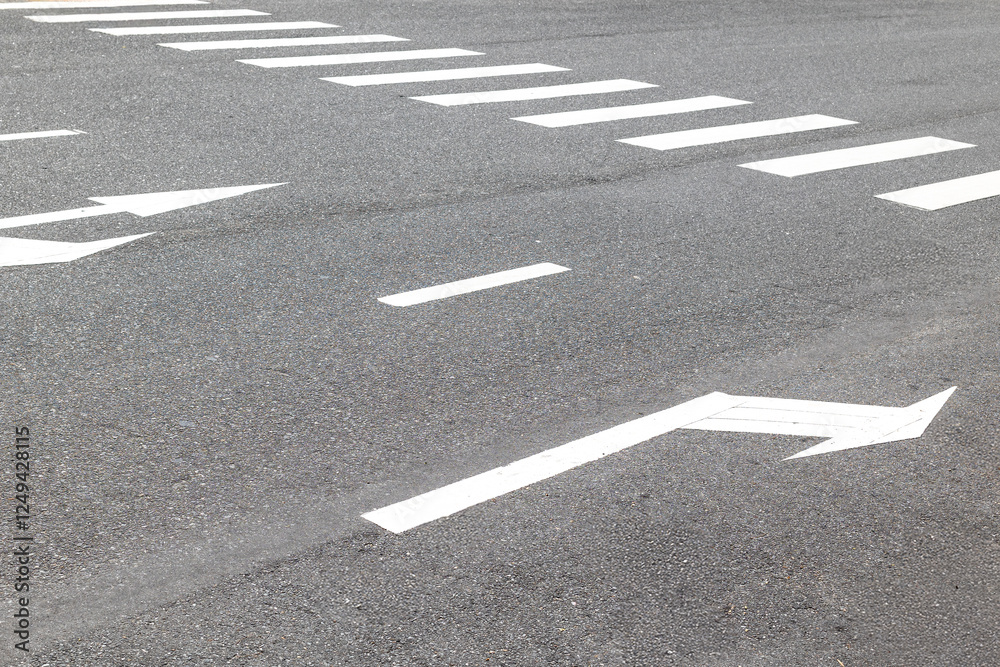Crosswalk with directional arrows on asphalt road surface Crosswalk with directional arrows on asphalt road surface